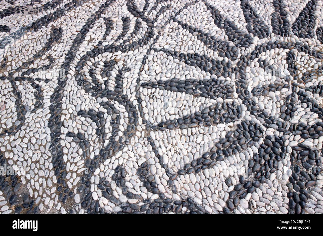 Popular sea pebble stone mosaic streets on island of Symi in Greece. Stock Photo