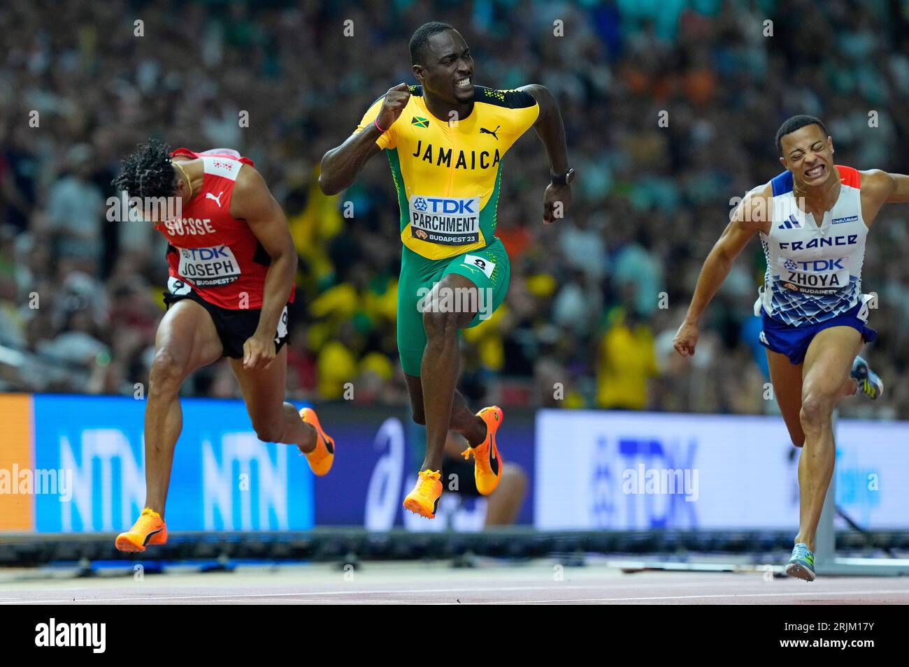 Hansle Parchment, of Jamaica, center, crosses the line to win the