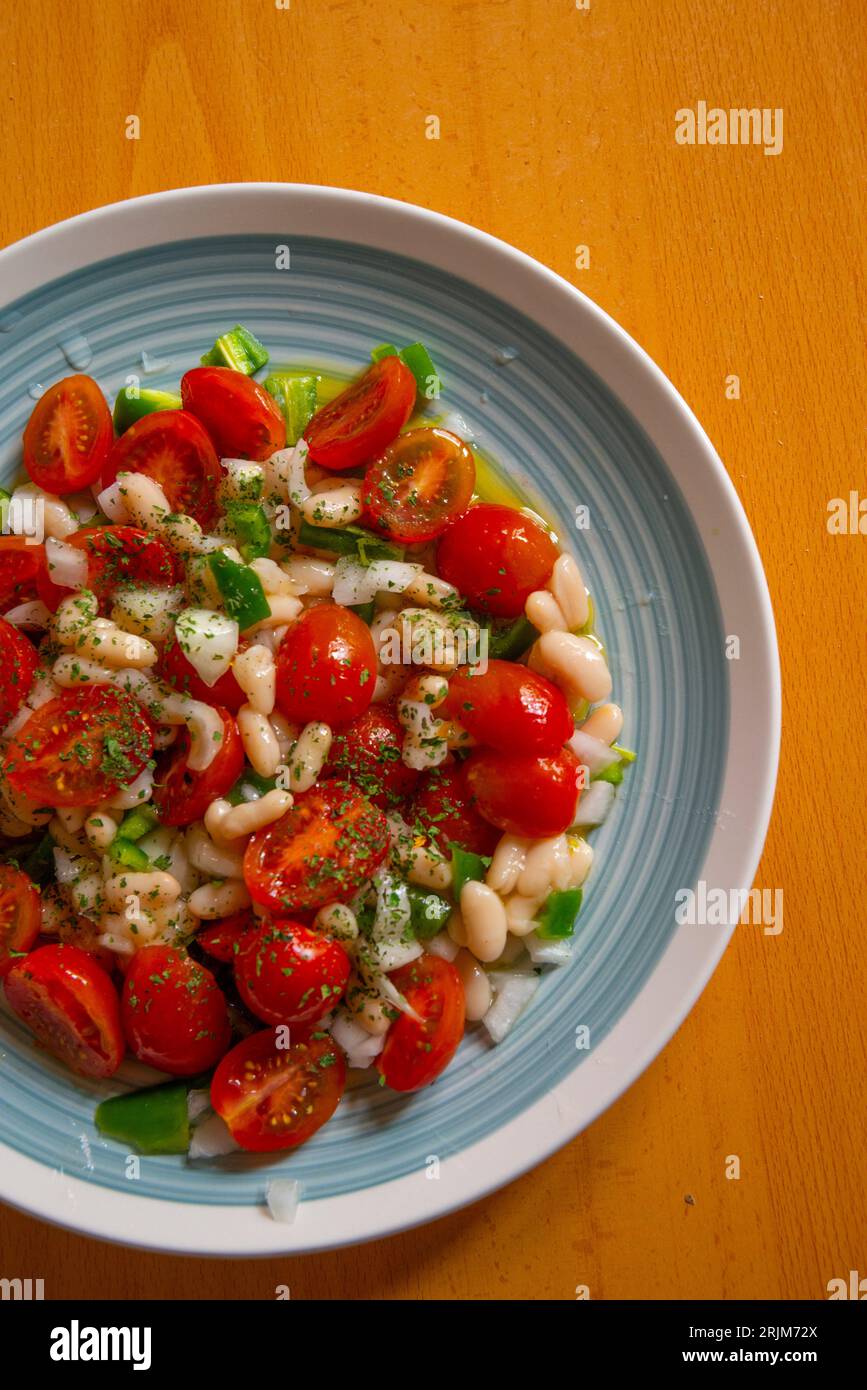 Salad made of beans, cherry tomatoes, green pepper, onion and olive oil. Stock Photo
