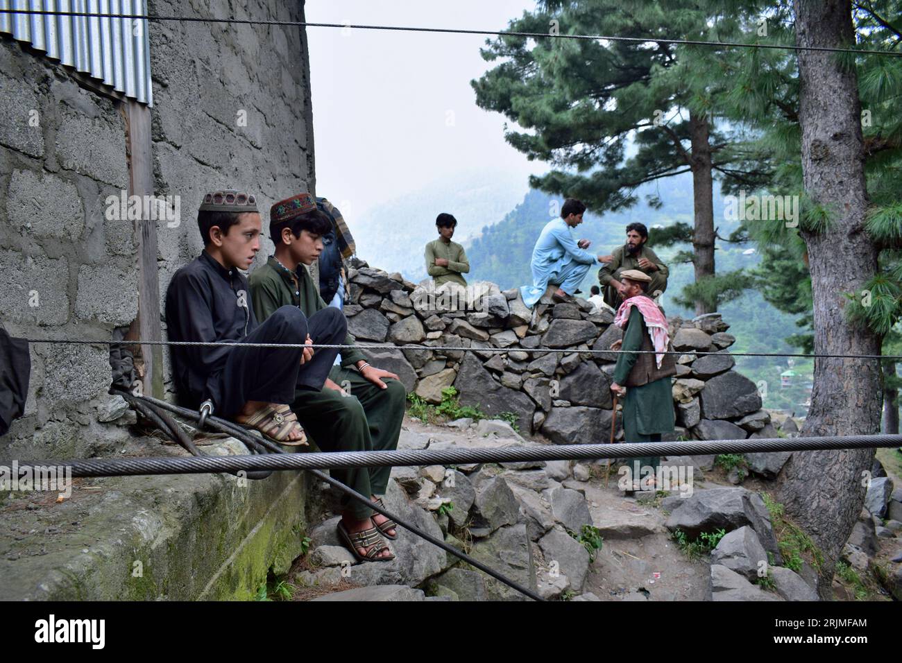 Local residents gather near the incident site, in Pashto village, a  mountainous area of Battagram district in Pakistan's Khyber Pakhtunkhwa  province, Wednesday, Aug. 23, 2023. The rescue of six school children and