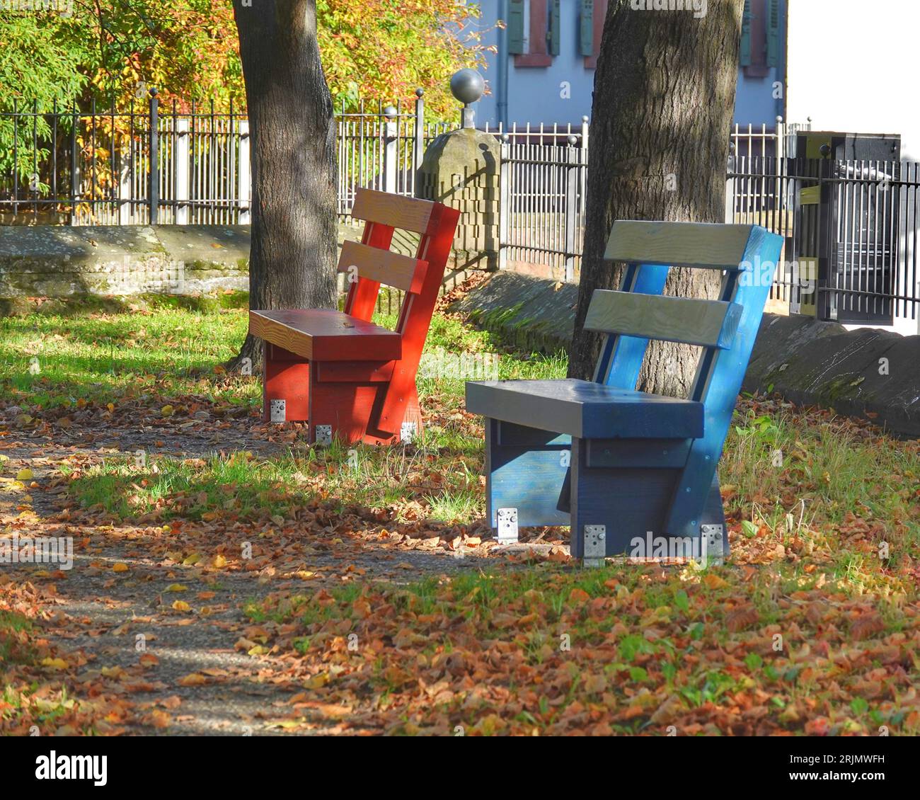 The two colorful benches under trees in a park Stock Photo - Alamy