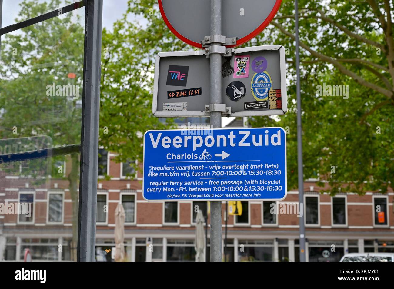 Blue sign in Katendrecht that directs cyclists on their way to the Charlois district to Ferry South with the departure times of that free facility. Stock Photo