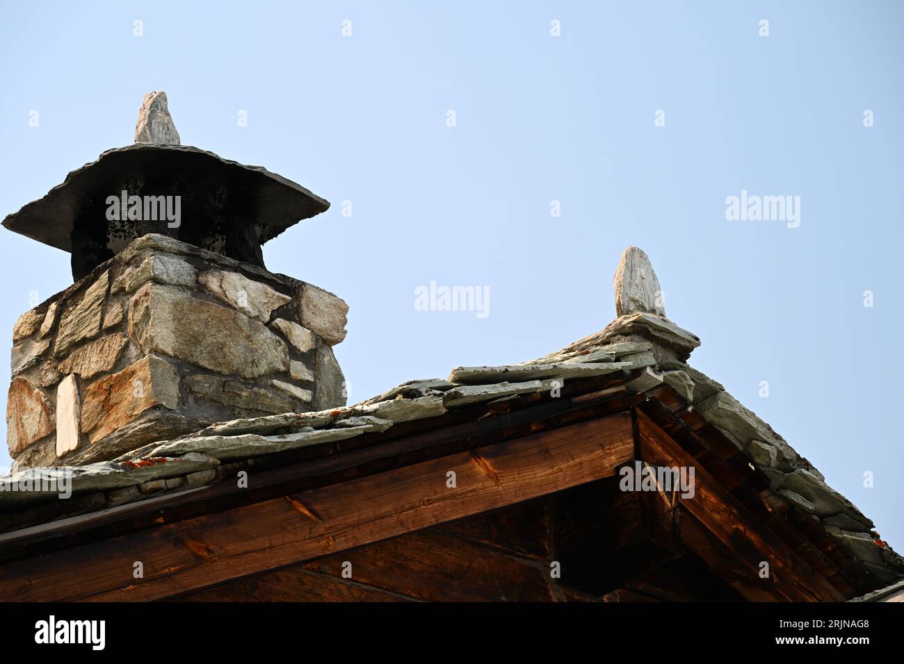 A low angle of a stone chimney against a blue sky Stock Photo