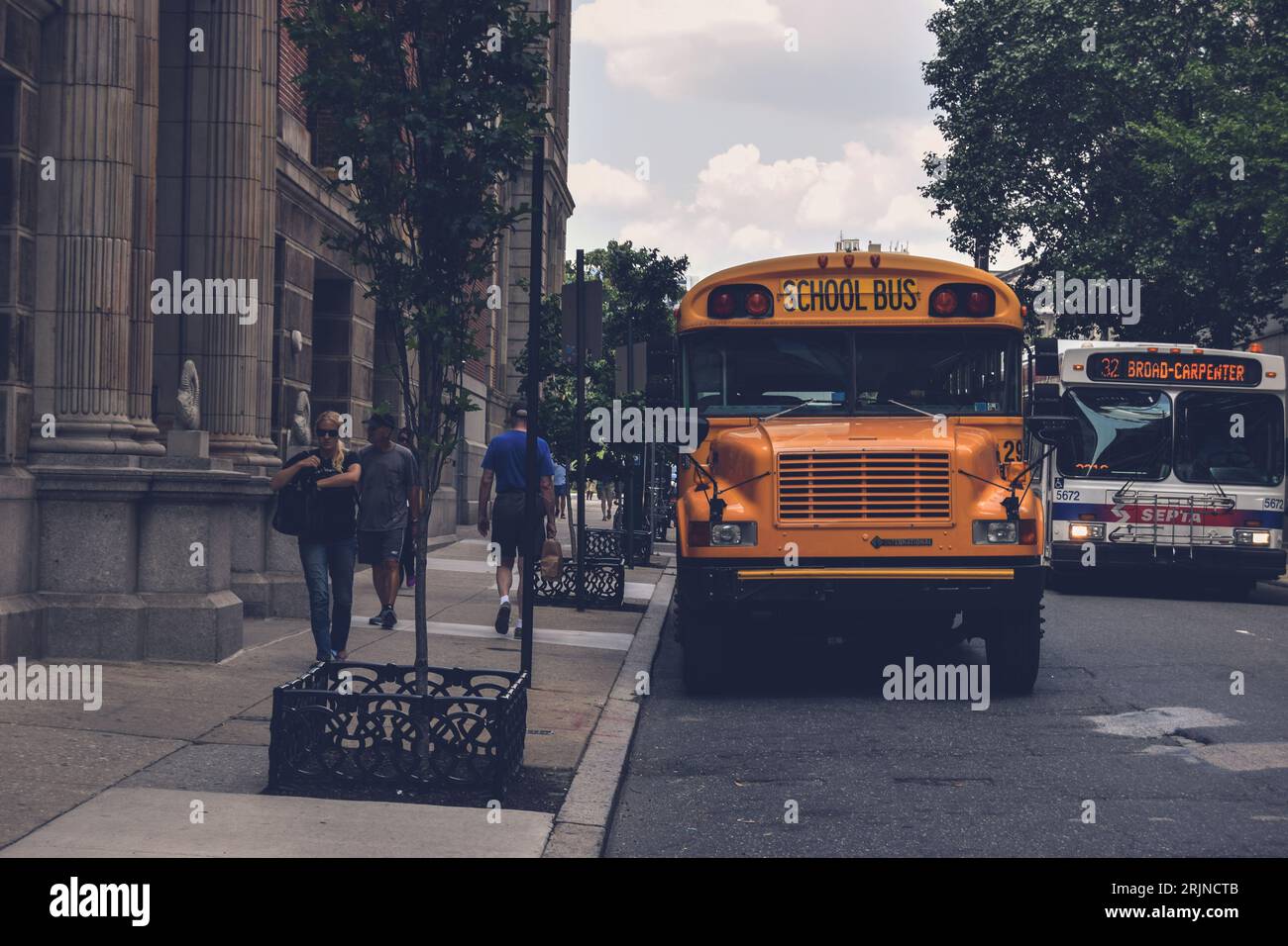 A closeup of a yellow school bus parked in front of a brick building ...