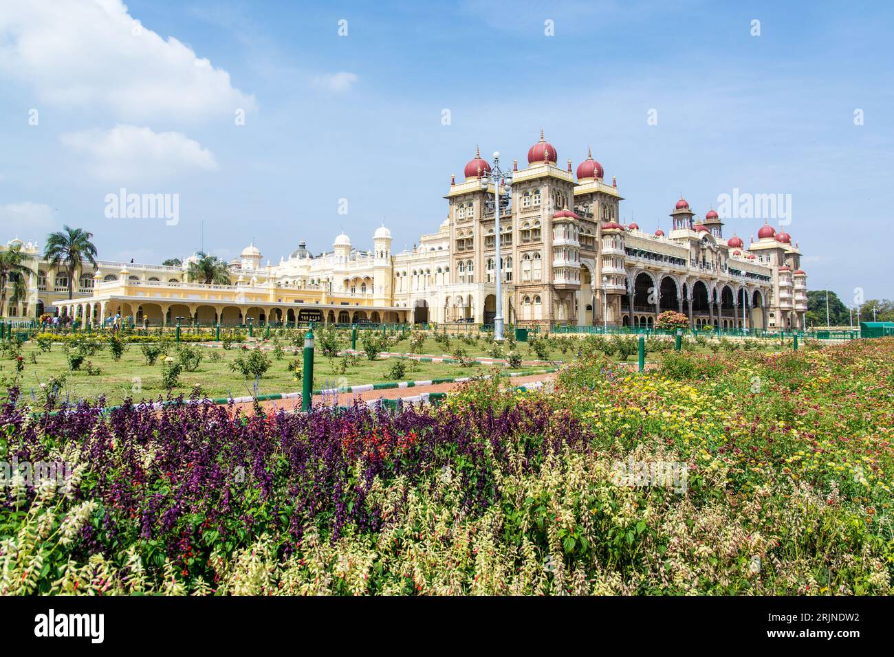 A closeup of a historical Amba Vilas Palace surrounded by lush flower beds in India Stock Photo