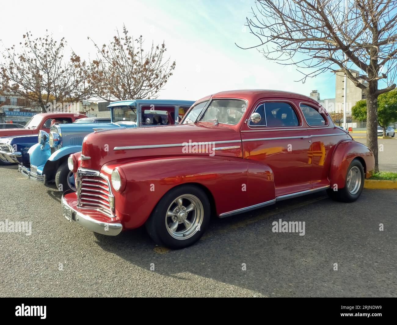 Old red shiny 1940s Chevrolet Fleetmaster coupe street rod in a parking lot. Classic car show Stock Photo