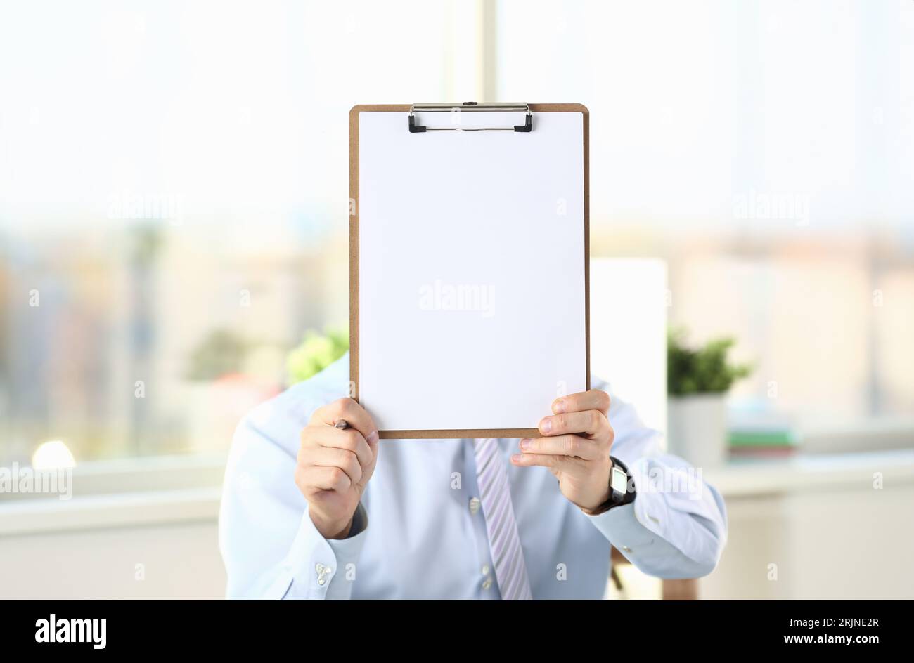 Businessman holds clipboard with paper Stock Photo
