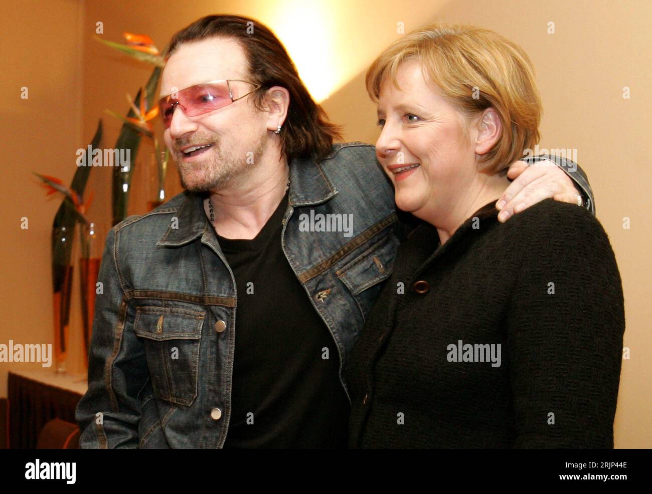 Sänger Bono Vox IRL/U2 und Bundeskanzlerin Angela Merkel GER/CDU posieren Arm in Arm am Rande des Weltwirtschaftsgipfels in Davos - PUBLICATIONxNOTxINxCHN Stock Photo