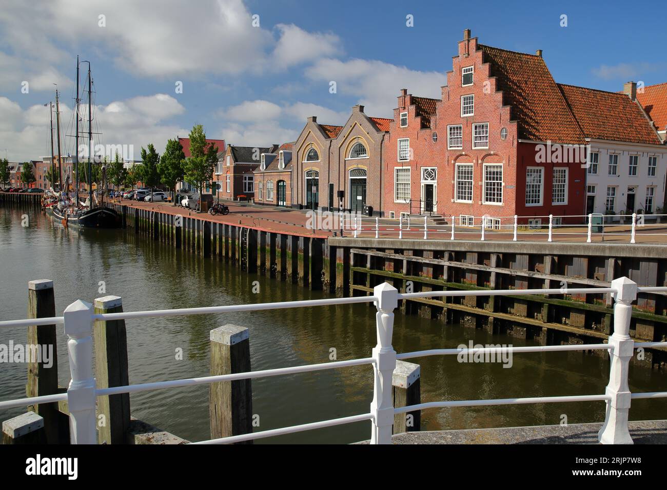 Historic buildings and old wooden sailing boats mooring at Zuiderhaven (Southern harbor) in Harlingen, Friesland, Netherlands Stock Photo