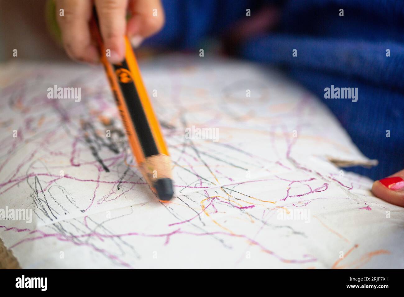 SYMBOL - 01 July 2023, Berlin: A toddler draws on his mom's lap with a colored pencil on a piece of cardboard. Photo: Fernando Gutierrez-Juarez/dpa Stock Photo