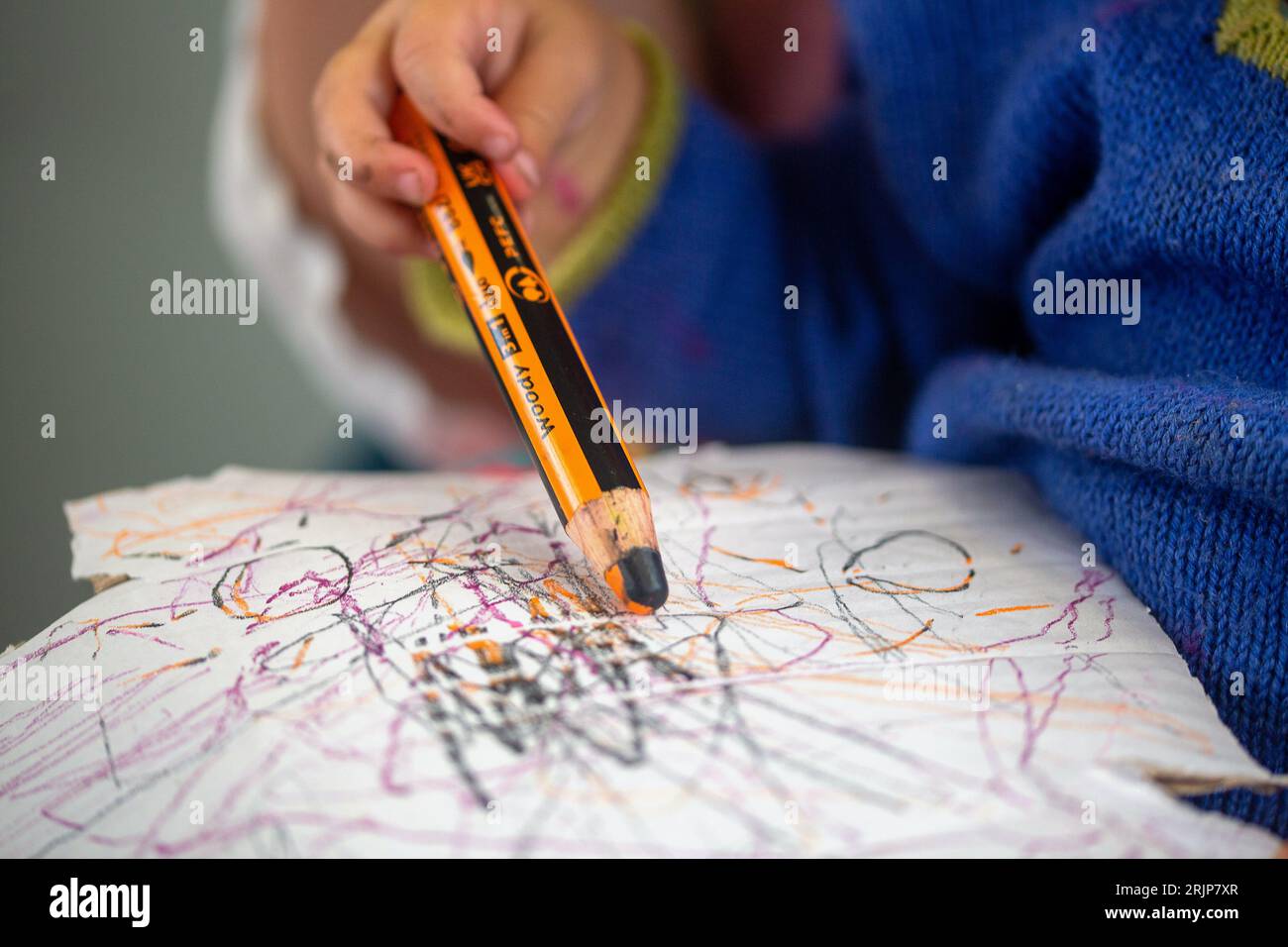 SYMBOL - 01 July 2023, Berlin: A toddler draws on his mom's lap with a colored pencil on a piece of cardboard. Photo: Fernando Gutierrez-Juarez/dpa Stock Photo