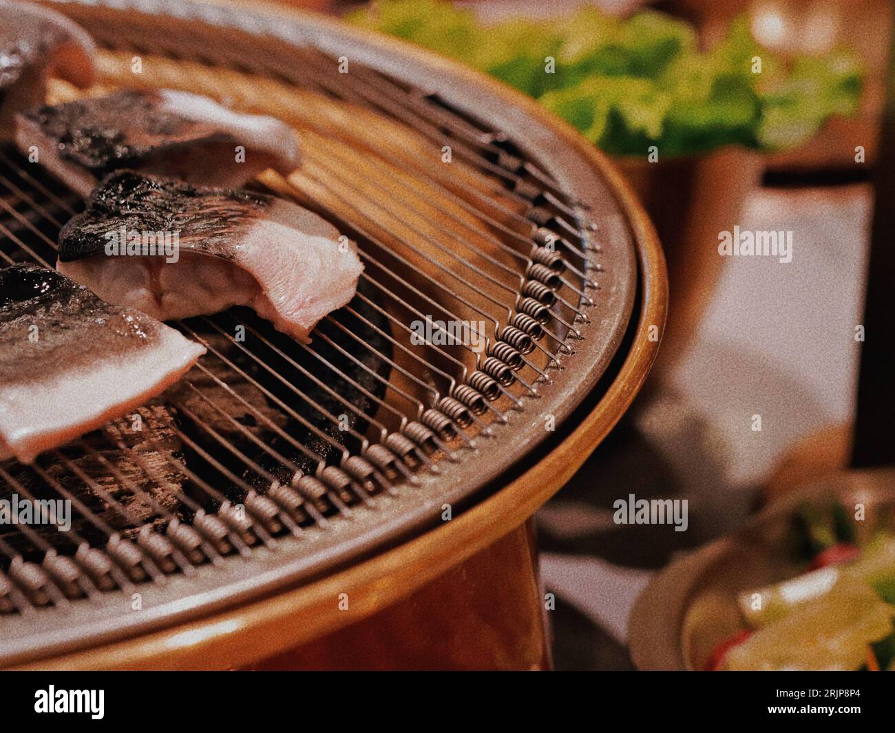 A barbecue grill full of sizzling meats with a blurred background Stock Photo