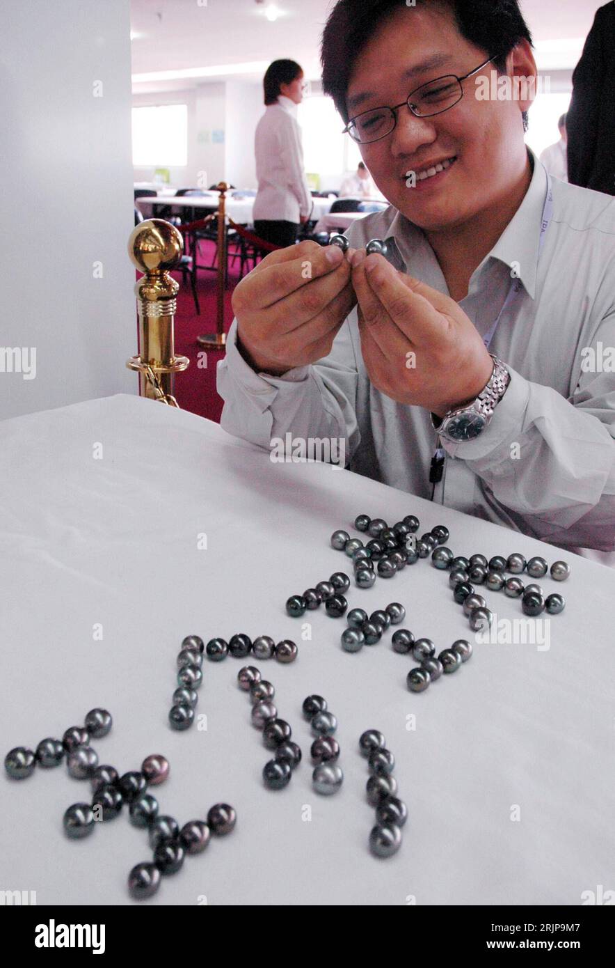 Bildnummer: 51134080  Datum: 24.02.2006  Copyright: imago/Xinhua Händler präsentiert seine schwarzen Perlen indem er aus ihnen das chinesische Wort für - Perle - legt - während der Eröffnung der internationalen Perlen-Messe in Suzhou PUBLICATIONxNOTxINxCHN, Personen , Objekte , optimistisch; 2006, Suzhou, Provinz Jiangsu, Mann, Männer, Geschäftsmann, Geschäftsmänner, lächeln, Schmuck, Schmuckstücke, Perle, Perlen, Luxus, Messe, Messen, schwarz, schwarze, internationale, Schriftzug; , hoch, Kbdig, , Einzelhandel, Wirtschaft, China / Verkäufer, Großhandel Stock Photo