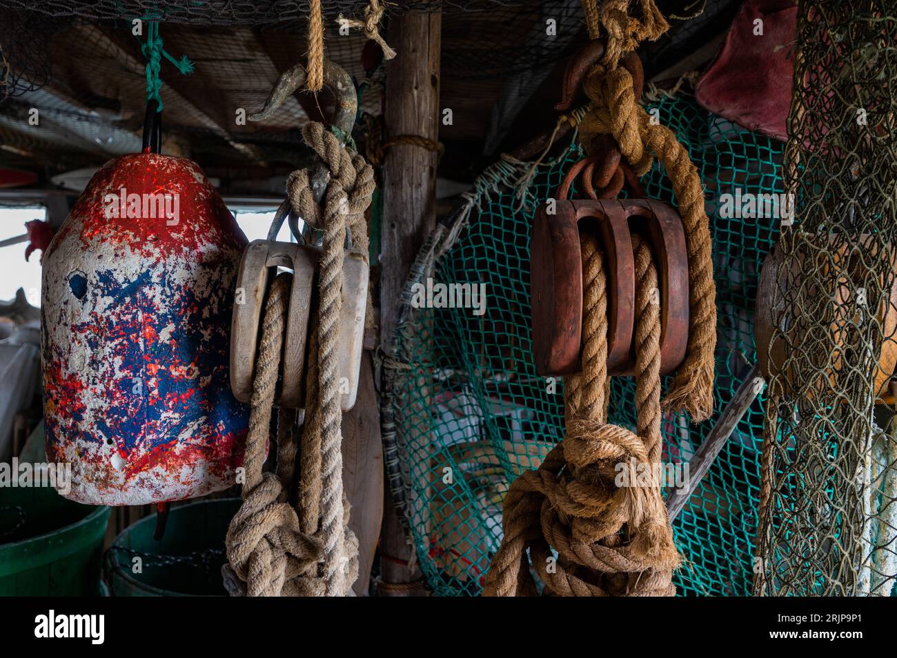 couple fishing ropes are tied and various objects are hanging from the ceiling Stock Photo