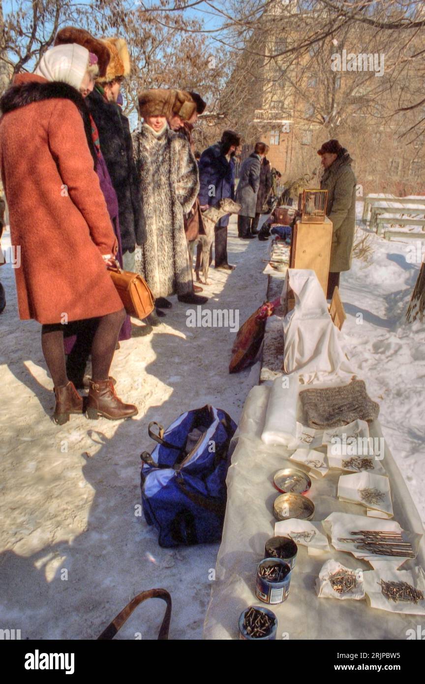 Volgograd, Russia - January 1996: Scanned film image, Russian flea market on the sidewalk during winter.   Editorial Stock Photo