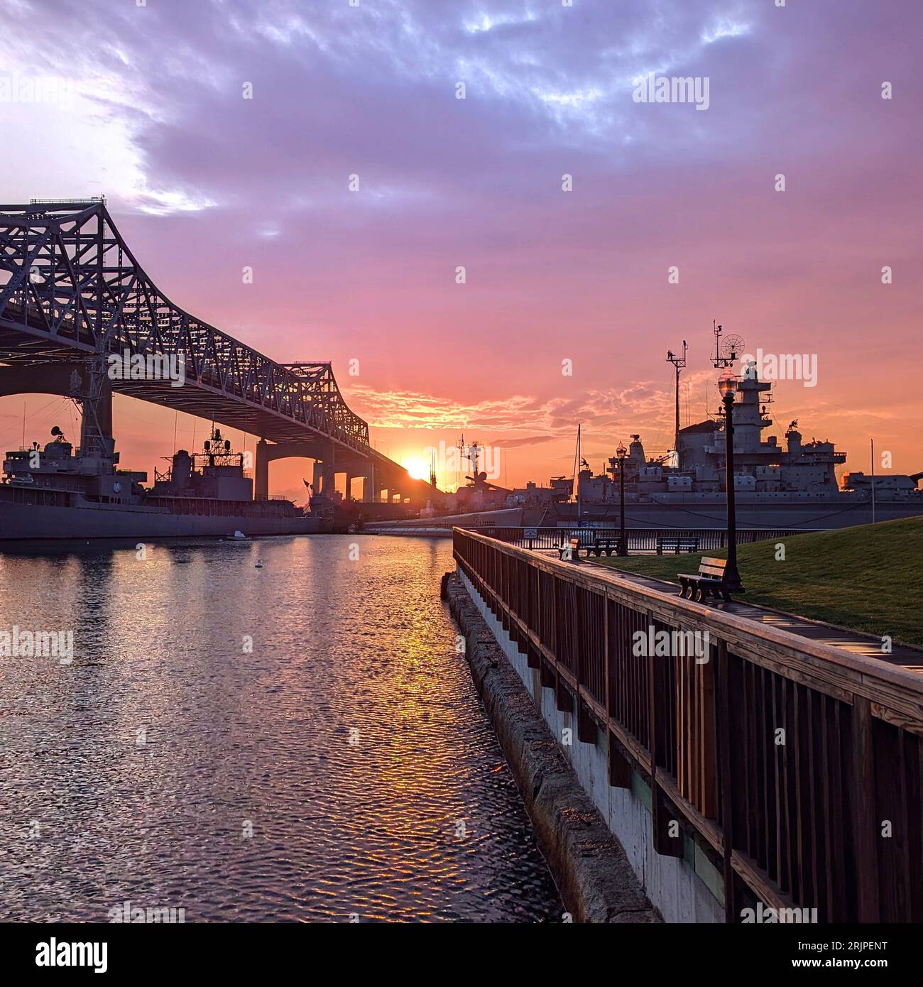 A stunning sunset view of an iron bridge spanning a large body of water