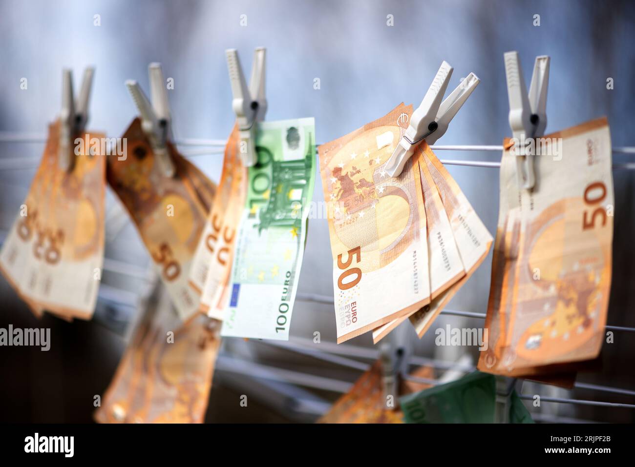 An array of fifty and one hundred Euro banknotes hanging from a clothing line Stock Photo