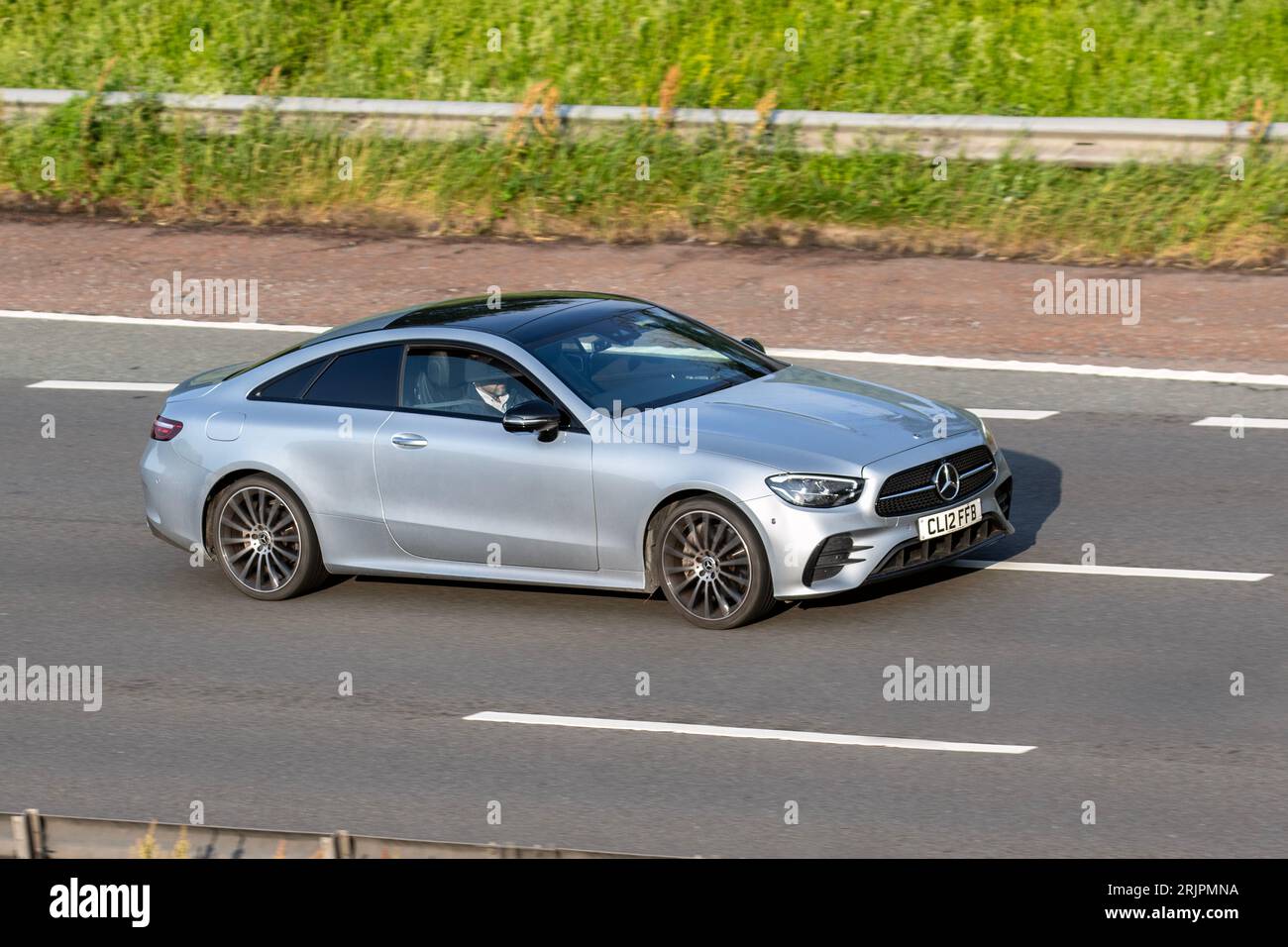 2022 Mercedes-Benz E 300 AMG LN NGT ED Prm+M travelling at speed on the M6 motorway in Greater Manchester, UK Stock Photo