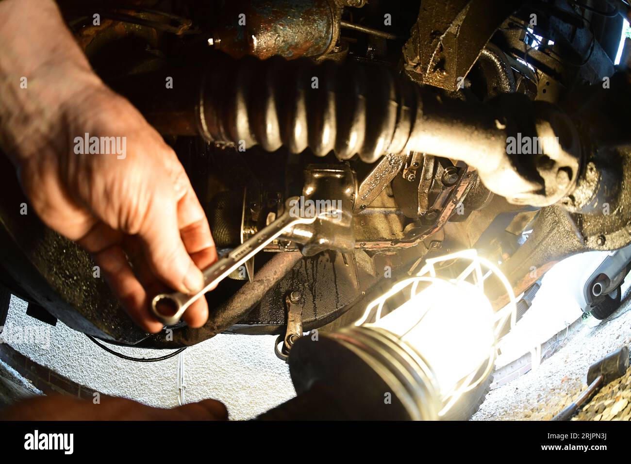 mechanic using inspection lamp working under vehicle Stock Photo Alamy