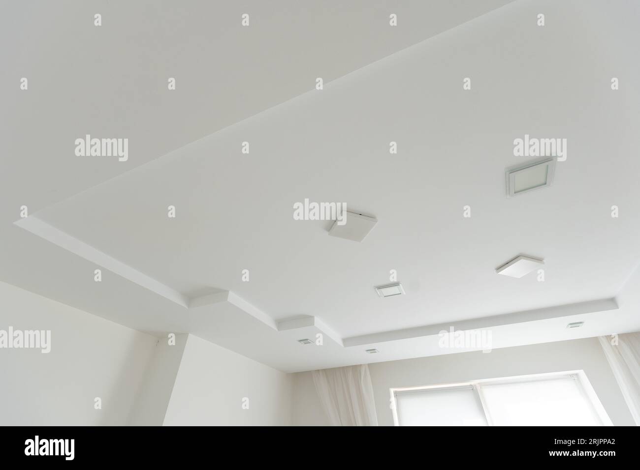 Stretched white matte ceiling in the room close-up Stock Photo