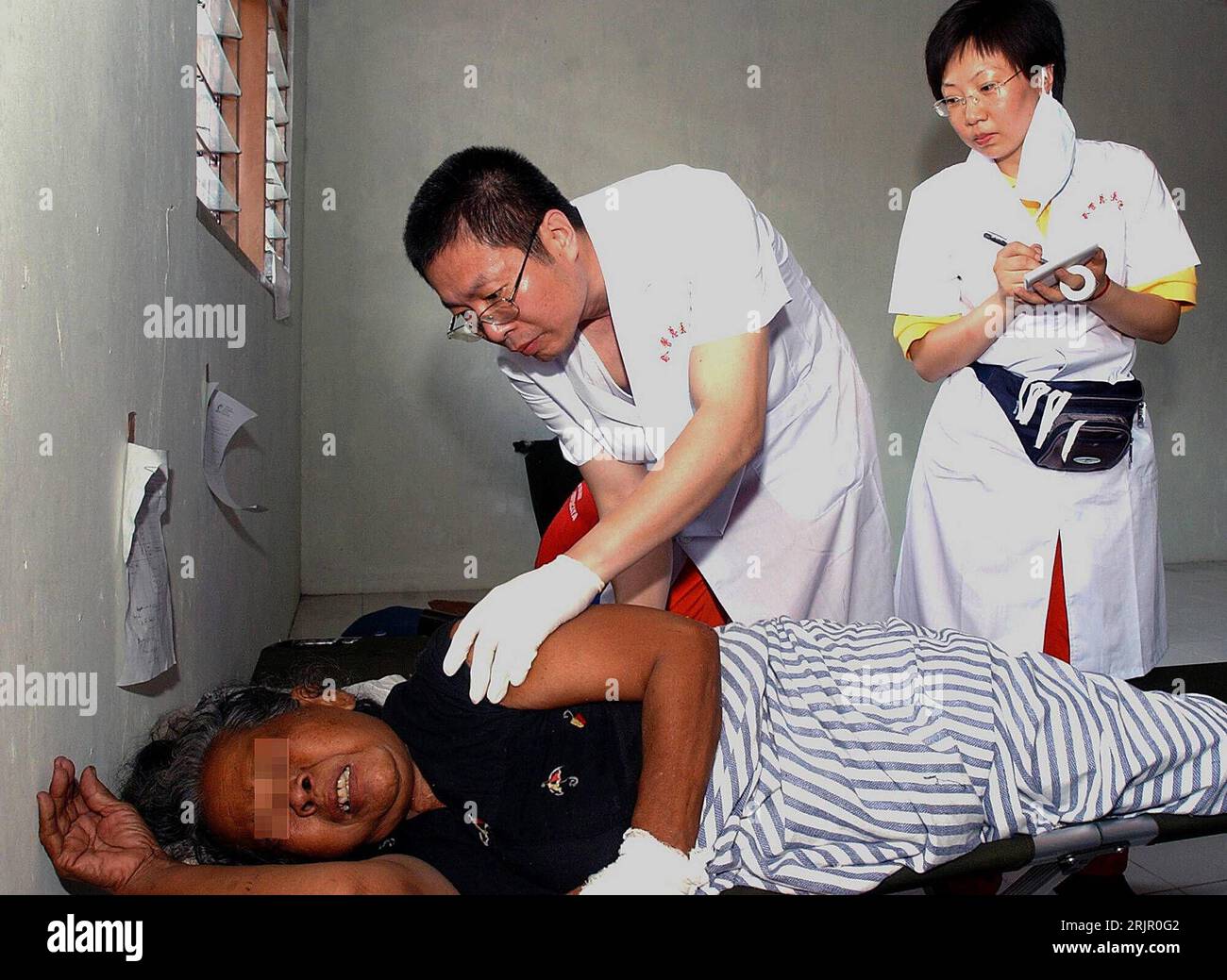 Bildnummer: 51266777  Datum: 31.05.2006  Copyright: imago/Xinhua Nach dem schweren Erdbeben in Indonesien behandeln der Arzt Cai Xiaojun und die Krankenschwester Liu Wanfang (beide CHN) Verletzte in Bantul, dem am stärksten betroffenen Stadtteil von Yogyakarta, Personen; 2006, Yogyakarta, Katastrophen, Katastrophe, Naturkatastrophen, Erdbeben, Folge, Folgen, Unterstützung, Erstversorgung, ärztliche Versorgung, Erste Hilfe, Ärzte, Verletzter, verletzt, Verletzte, Opfer, Erdbebenopfer, Java, Beben, Krankenhaus, Krankenhäuser, Krankenstation, Krankenstationen; , quer, Kbdig, Gruppenbild, Indonesi Stock Photo