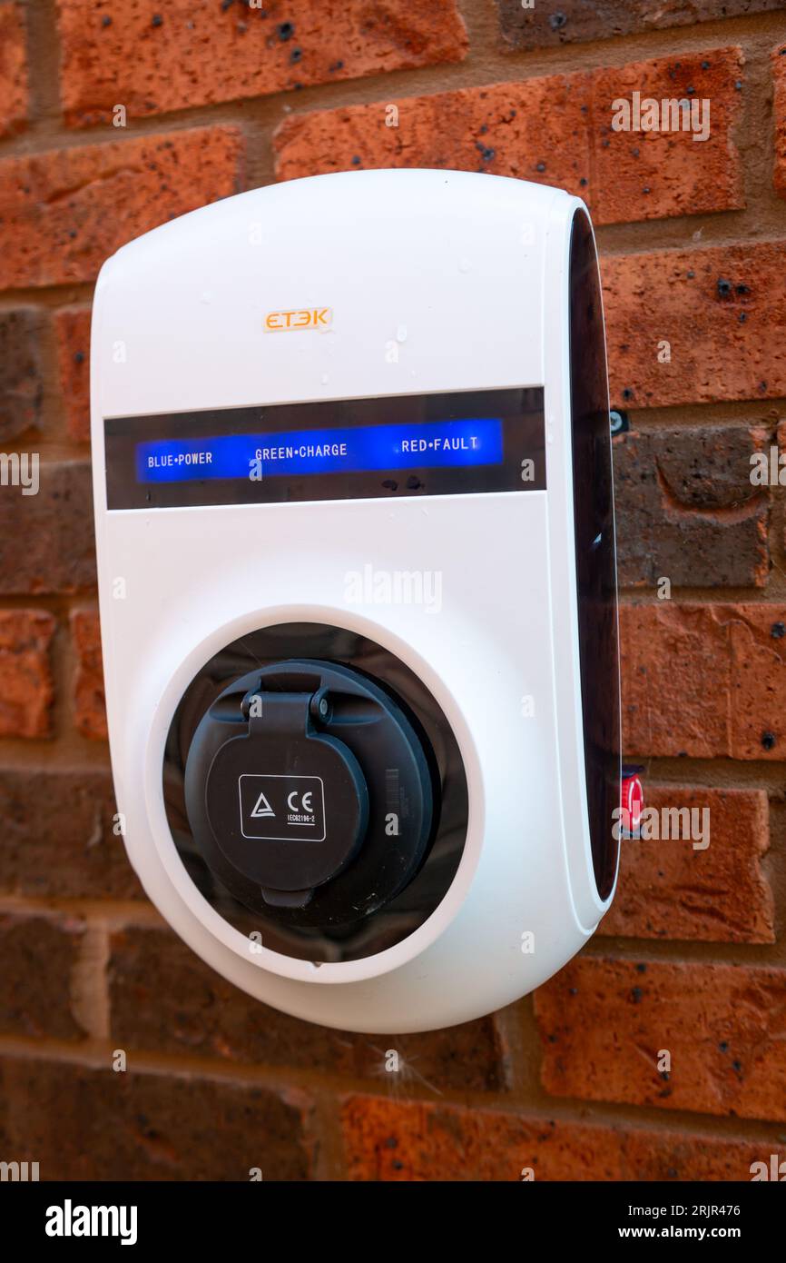 Domestic car charging point on the outside wall of a house, UK 20232 Stock Photo