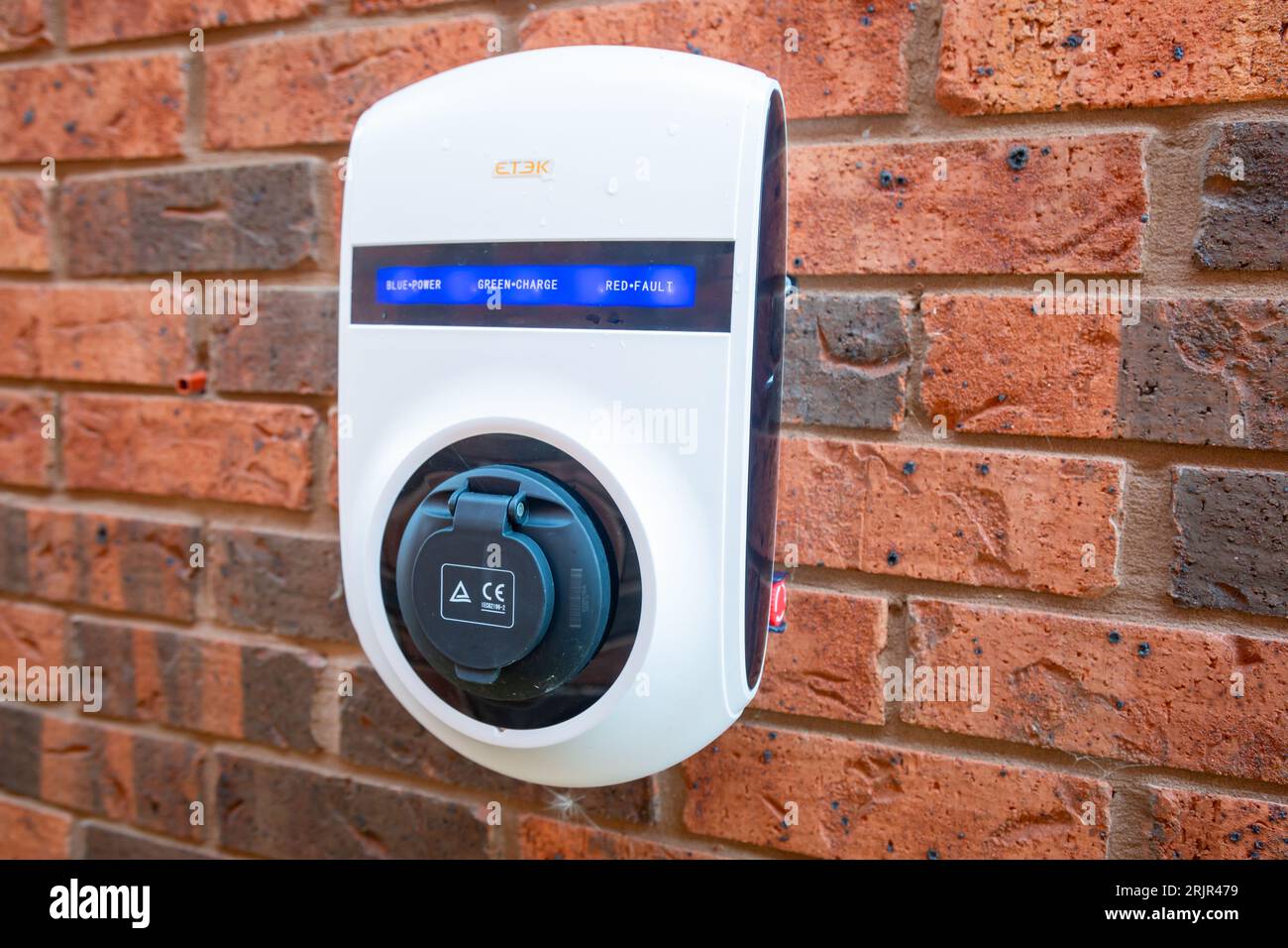 Domestic car charging point on the outside wall of a house, UK 20232 Stock Photo