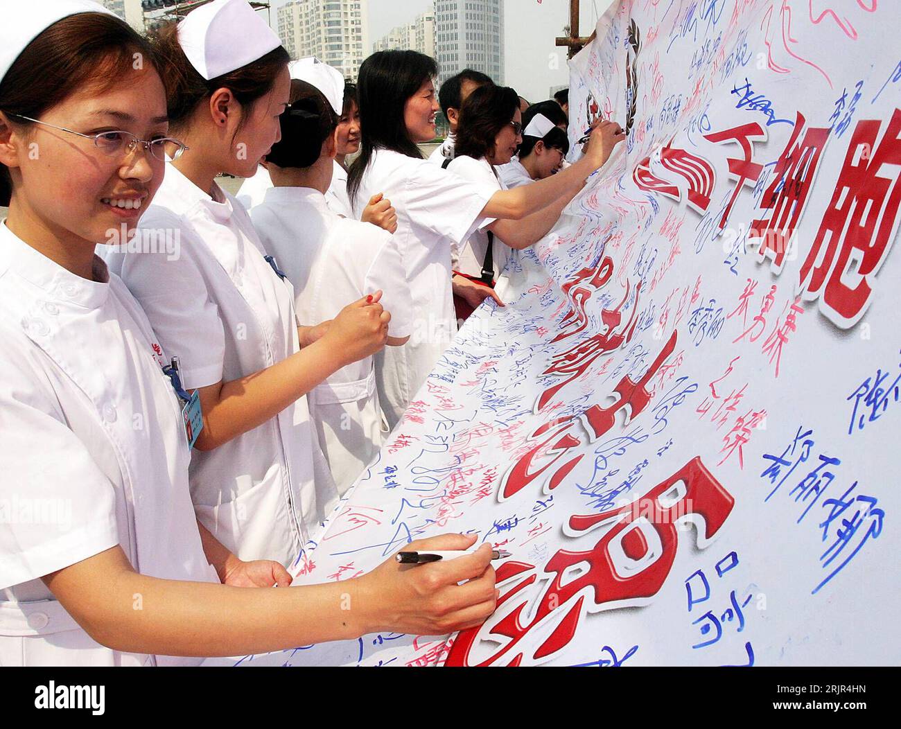 Bildnummer: 51293241  Datum: 12.06.2006  Copyright: imago/Xinhua Krankenschwestern signieren ein Plakat während eines Spendenaufrufs für die Stammzellenforschung im chinesischen Qinghuangdao - PUBLICATIONxNOTxINxCHN, Personen; 2006, Qinghuangdao, Krankenschwester, unterschreiben, Unterschrift, Unterschriftenaktion, Plakate, Spendenaufruf; , quer, Kbdig, Gruppenbild, China,  , Medizin, Wissenschaft, Stock Photo