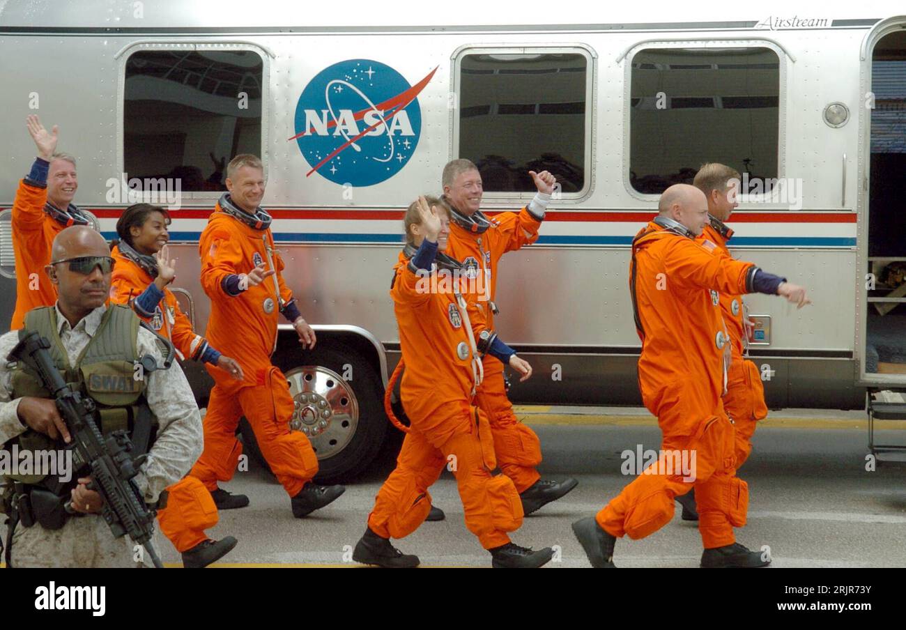 Bildnummer: 51315492  Datum: 02.07.2006  Copyright: imago/Xinhua Bewaffneter Soldat schützt die Besatzung der Discovery auf dem Weg zum Space Shuttle der Mission STS-121 - Pilot Mark Kelly (vorn li., USA), Kommandant Steven Lindsay (vorn re., USA), Missionsspezialistin Lisa Nowak (2.Reihe li., USA) Missionsspezialist Michael Fossum (2.Reihe re., USA), Missionsspezialistin Stephanie Wilson (3.Reihe li., USA), Missionsspezialist Piers Sellers (4.Reihe li., USA) und Thomas Reiter (hinten, GER) verabschieden sich in Cape Canaveral - PUBLICATIONxNOTxINxCHN, Personen , optimistisch; 2006, Cape Canav Stock Photo