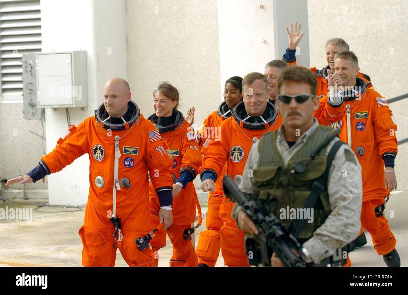 Bildnummer: 51315487  Datum: 02.07.2006  Copyright: imago/Xinhua Bewaffneter Soldat schützt die Besatzung der Discovery auf dem Weg zum Space Shuttle der Mission STS-121 - Pilot Mark Kelly (vorn li., USA), Kommandant Steven Lindsay (vorn re., USA), Missionsspezialistin Lisa Nowak (2.Reihe li., USA) Missionsspezialist Michael Fossum (2.Reihe re., USA), Missionsspezialistin Stephanie Wilson (3.Reihe li., USA), Missionsspezialist Piers Sellers (4.Reihe li., USA) und Thomas Reiter (hinten, GER) verabschieden sich in Cape Canaveral - PUBLICATIONxNOTxINxCHN, Personen; 2006, Cape Canaveral, Presseter Stock Photo