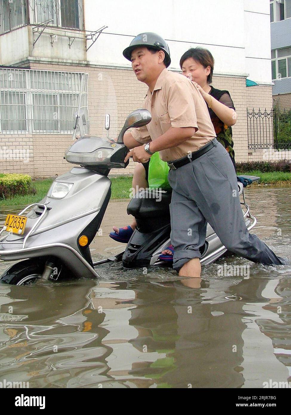 Bildnummer: 51320334  Datum: 05.07.2006  Copyright: imago/Xinhua Einheimisches Paar schiebt seinen Motorroller über eine nach schweren Regenfällen überfluteten Straße in Chaohu, China - PUBLICATIONxNOTxINxCHN, Personen , Objekte; 2006, Chaohu, Hochwasser, Überschwemmung, Überschwemmungen, Katastrophe, Katastrophen, Naturkatastrophen , Flut, Fluten, Flutkatastrophe, Flutkatastrophen, überschwemmt, überschwemmte, überflutet, überflutete, Moped, Mopeds, Roller, Frau, Frauen, Mann, Männer, Paare, Einheimischer, Einheimische; , hoch, Kbdig, Gruppenbild, Seitenansicht, Perspektive, China,  , Straße, Stock Photo