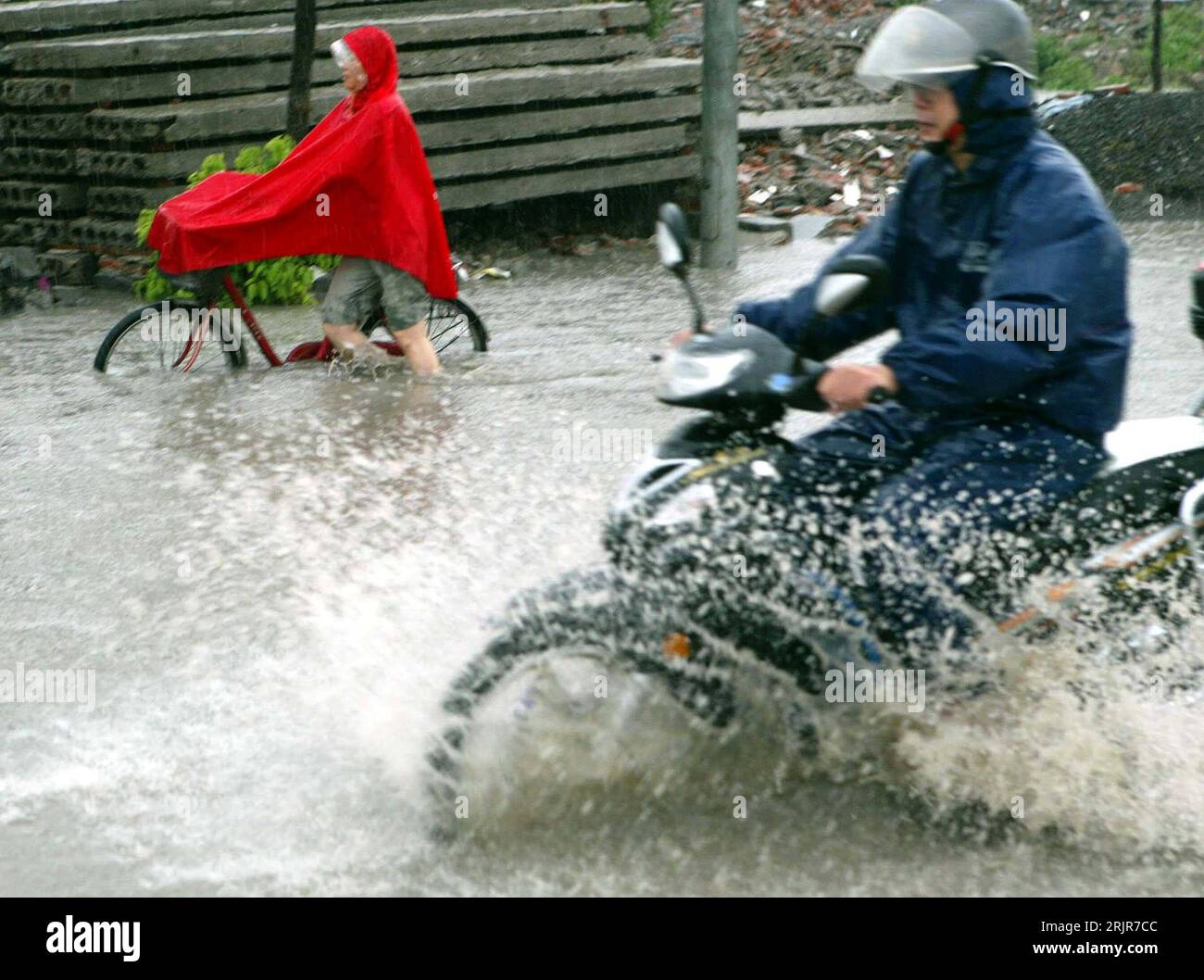Bildnummer: 51320325  Datum: 05.07.2006  Copyright: imago/Xinhua Mann auf einem Motorroller und ein Fahrradfahrer fahren nach schweren Regenfällen über eine überflutete Straße in Shanghai - PUBLICATIONxNOTxINxCHN, Personen , Dynamik; 2006, Shanghai, Hochwasser, Überschwemmung, Überschwemmungen, Katastrophe, Katastrophen, Naturkatastrophen , Flut, Fluten, Flutkatastrophe, Flutkatastrophen, überschwemmt, überschwemmte, überflutet, Männer, Roller, Moped, Mopeds, Radfahrer; , quer, Kbdig, Gruppenbild, Seitenansicht, Perspektive, China,  , Straße, Verkehr, Wetter, Unwetter Stock Photo