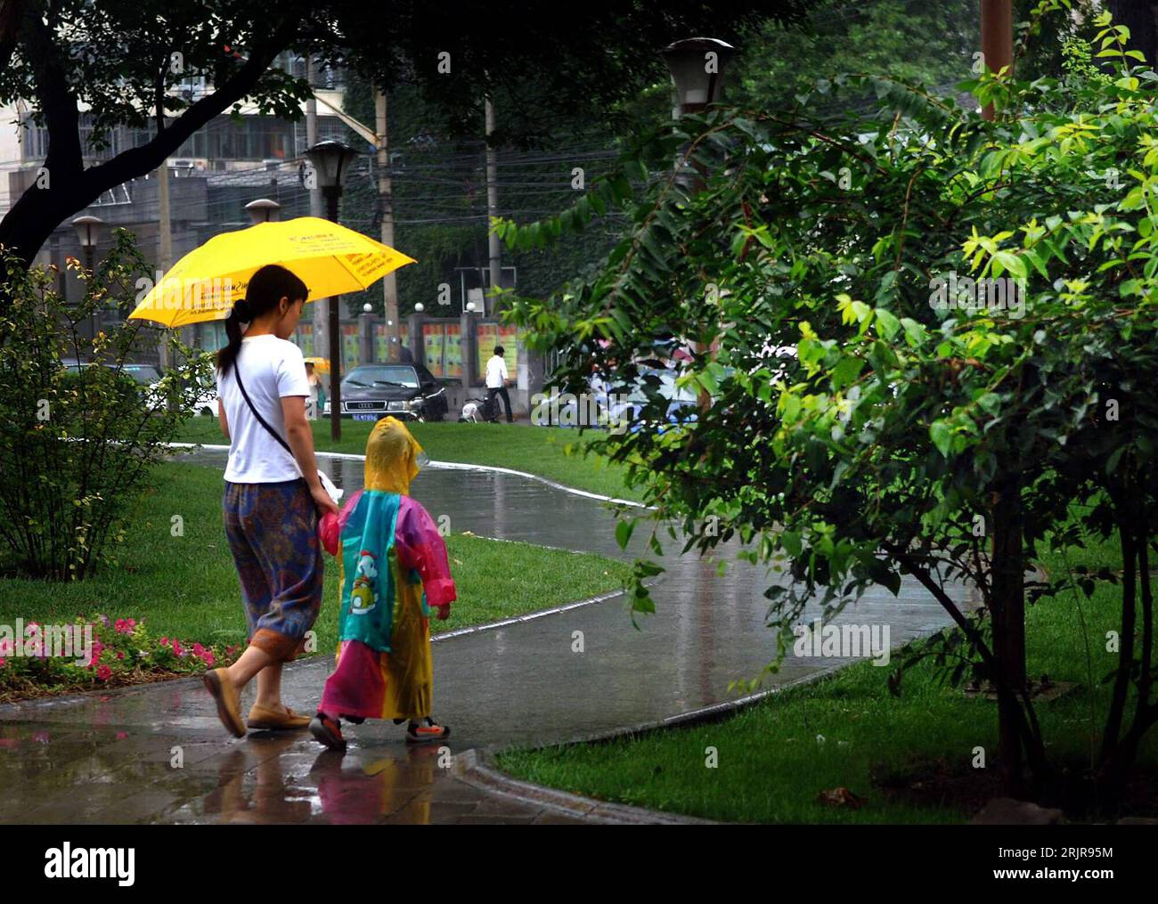 Bildnummer: 51340701  Datum: 18.07.2006  Copyright: imago/Xinhua Mutter mit Kind unter einem Regenschirm während eines Regens in Peking - PUBLICATIONxNOTxINxCHN, Personen , Landschaft; 2006, Peking, Regenschirme, Schirm, Schirme, Städte, Land, Leute, Einheimische, Einheimischer, Frau, Frauen, Kinder, Park, Parks, Regen, regnet, regnend, Regenwetter,; , quer, Kbdig, Totale, China,  , Wetter Stock Photo