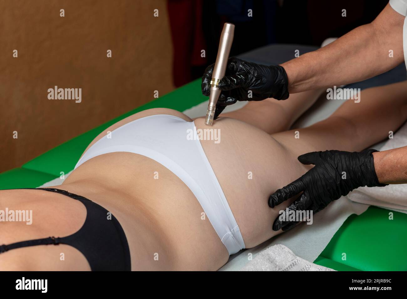 A woman lies on a massage table in a spa, receiving an aesthetic treatment for beauty, body and skin care Stock Photo