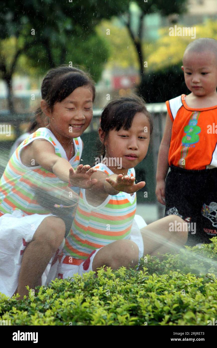 Bildnummer: 51382731  Datum: 30.07.2006  Copyright: imago/Xinhua Mädchen spielen mit Wasser in Hefei - PUBLICATIONxNOTxINxCHN, Personen , optimistisch; 2006, Hefei, Anhui, Kind, Kinder, Einheimischer, Einheimische, Land, Leute, Chinese, Chinesen, Chinesin, Erfrischung, erfrischen, Hitze, Hitzewelle, , Junge,; , hoch, Kbdig, Gruppenbild, China,  , Wetter Stock Photo