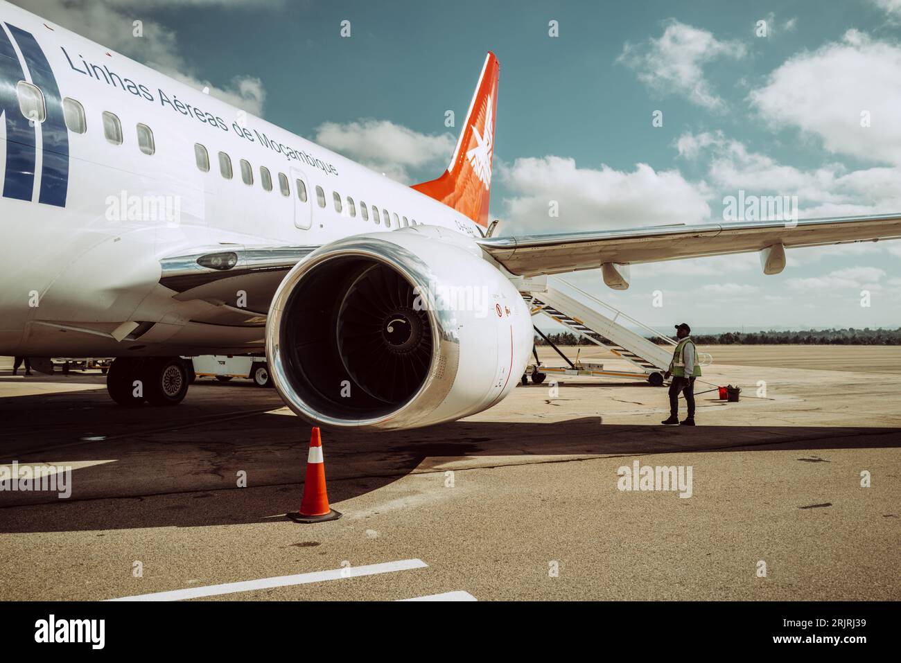 An instructor standing at an airplane on a runway in Nampula, Mozambique Stock Photo