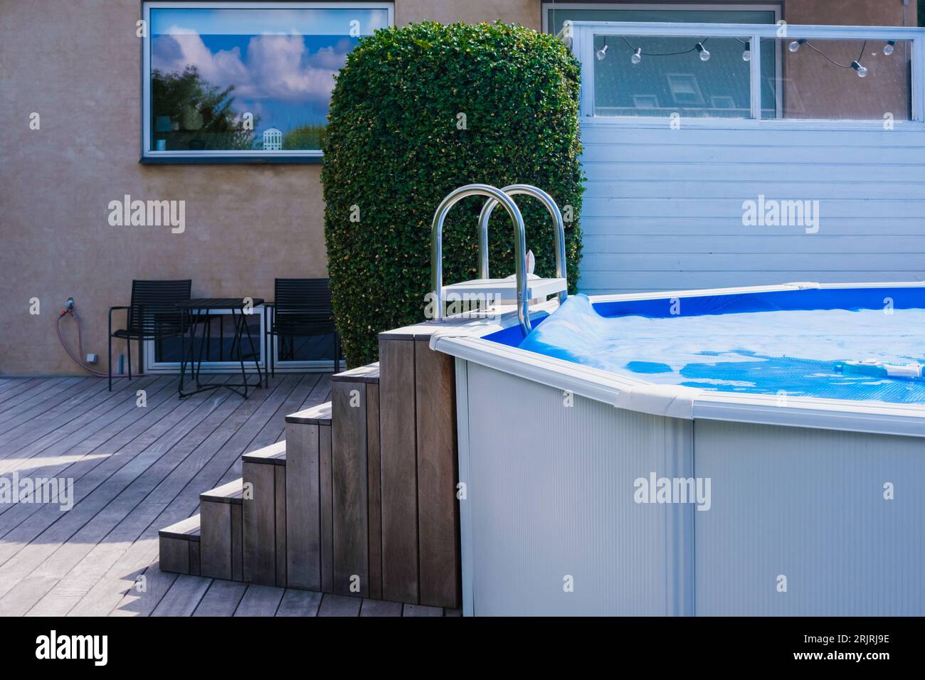 Detail of a portable pool, mounted in the backyard, decorated with wood ...