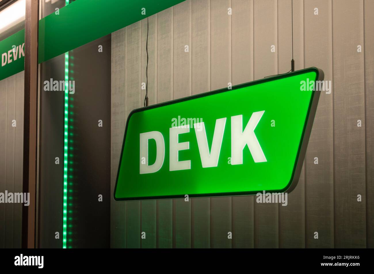 Germany , Cottbus , 22.08.2023 , Illuminated sign of insurance company DEVK in a window of a branch office Stock Photo