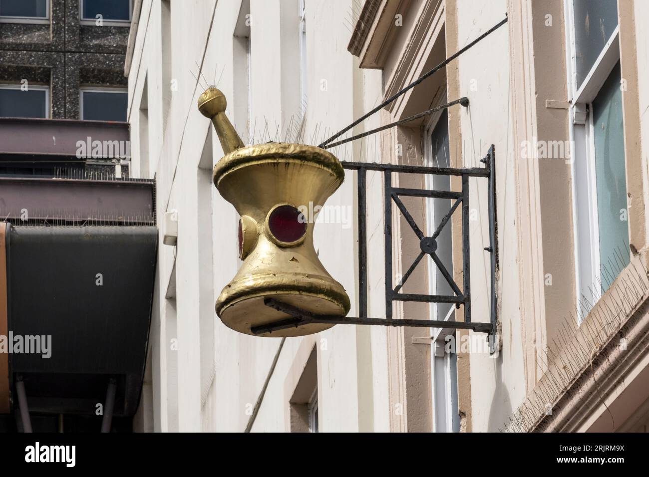 Traditional mortar and pestle sign on a building, indicating a