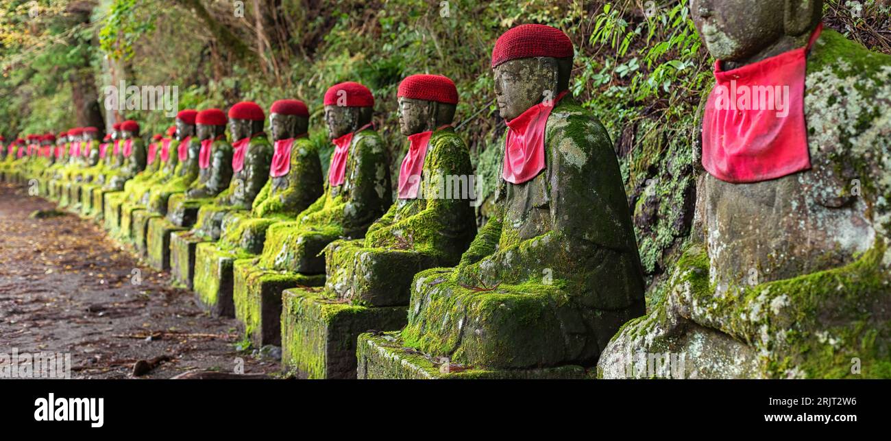 Moss covered Jizo statues, wearing red hats and bibs, at Kanmangafuchi