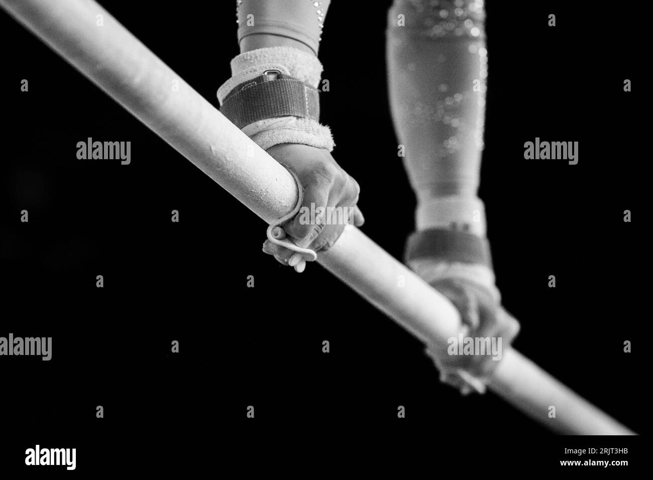 A determined athlete is performing a skillful routine on the parallel