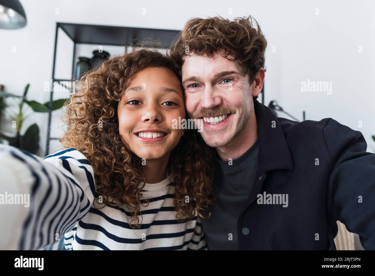 Father and daughter capture a joyful moment with a selfie, free from worries and enjoying each other's company Stock Photo