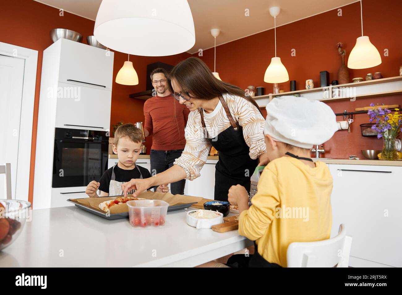 Mother with sons preparing pizza at home Stock Photo
