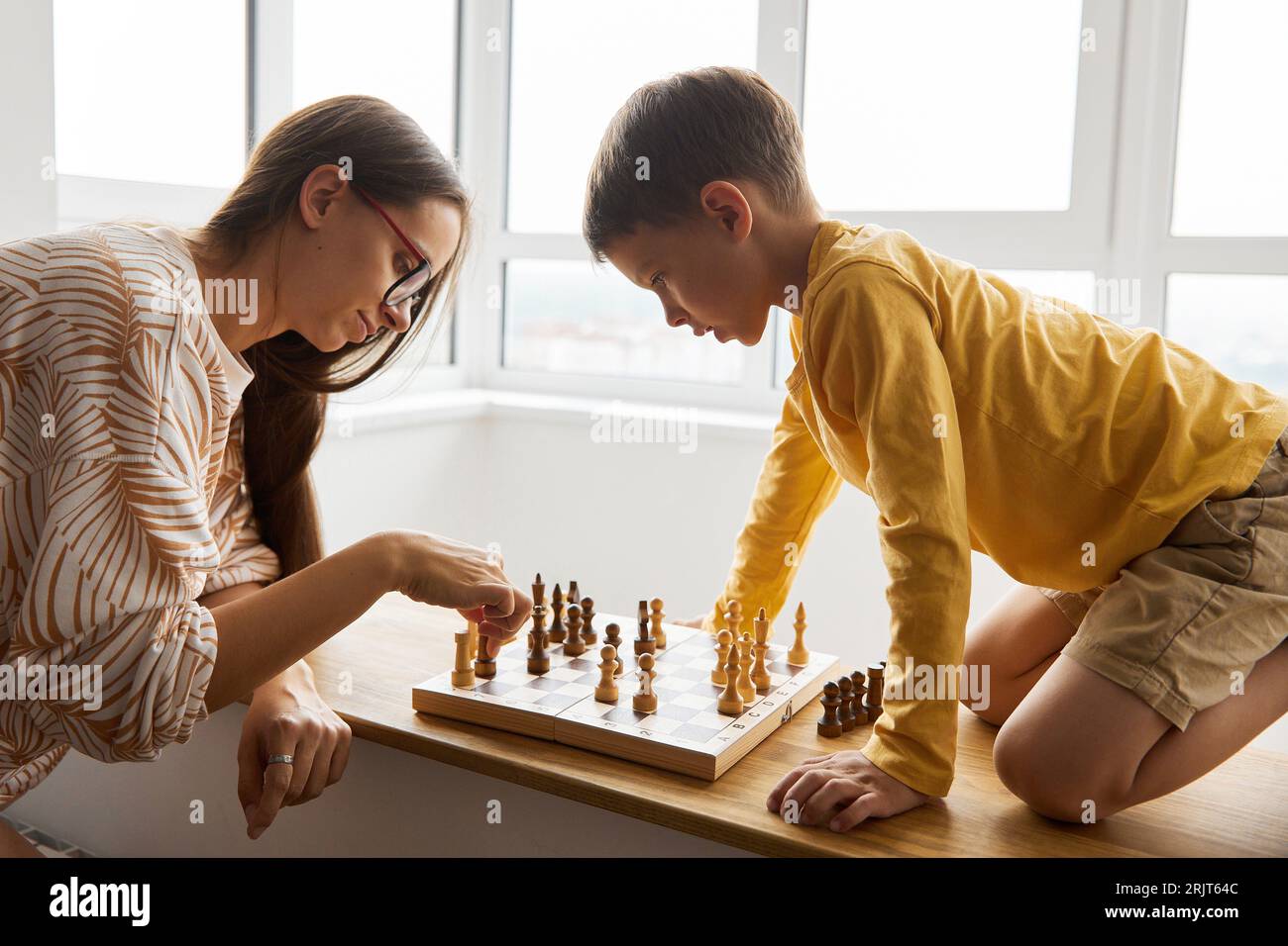 Mother playing chess with son at home Stock Photo Alamy