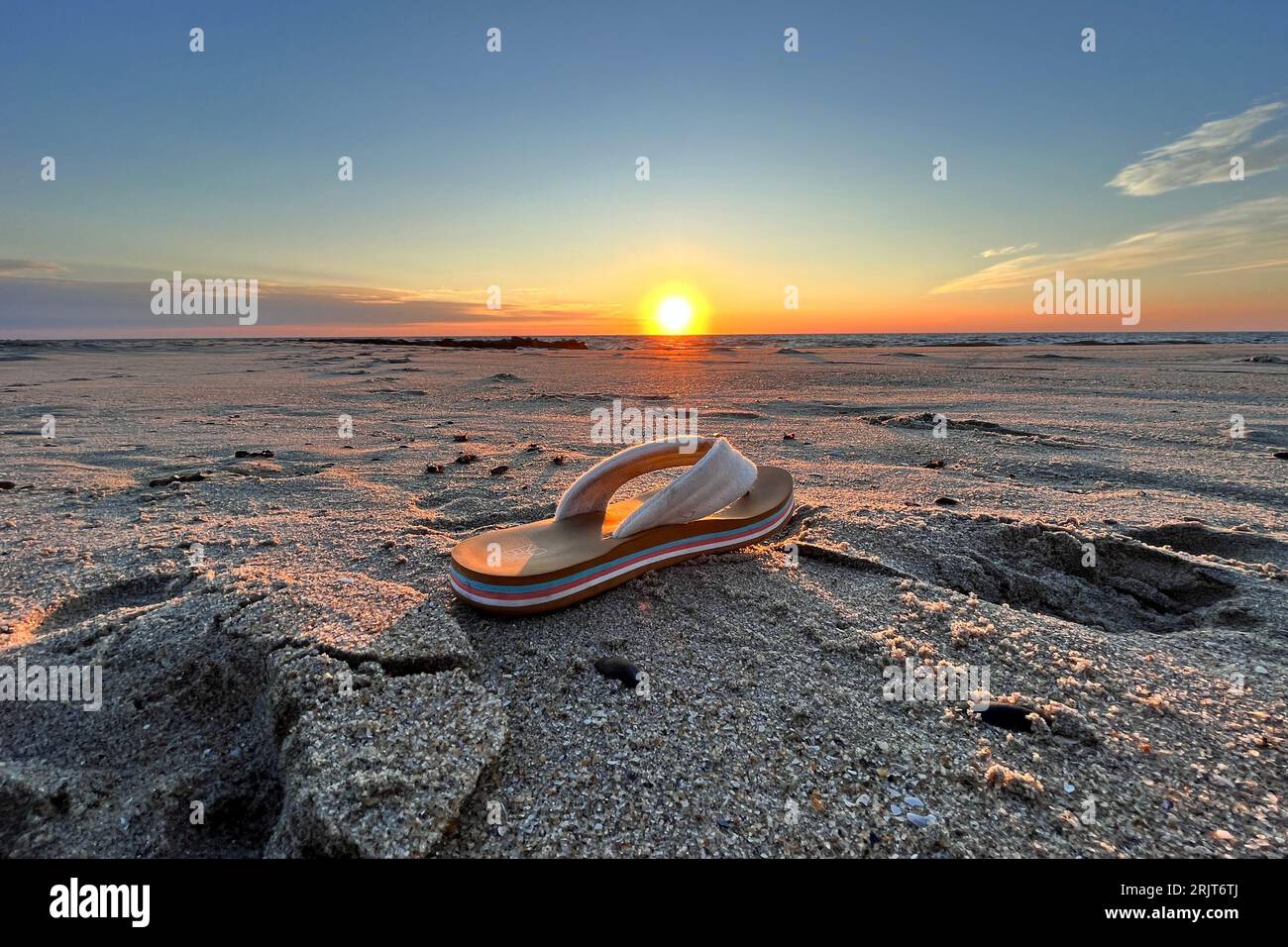 Bradley Beach, United States. 23rd Aug, 2023. The sun rises behind flip flop left on the beach of a shore town in New Jersey, United States on August 23, 2023. Credit: OOgImages/Alamy Live News Stock Photo
