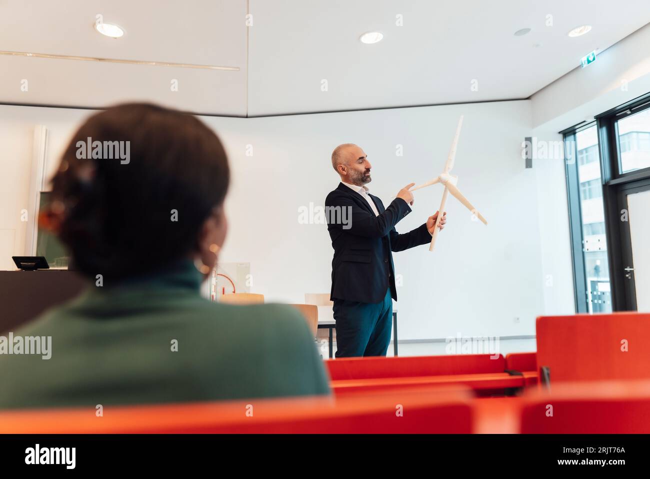 Mature businessman giving presentation and having discussion over wind turbine with businesswoman Stock Photo