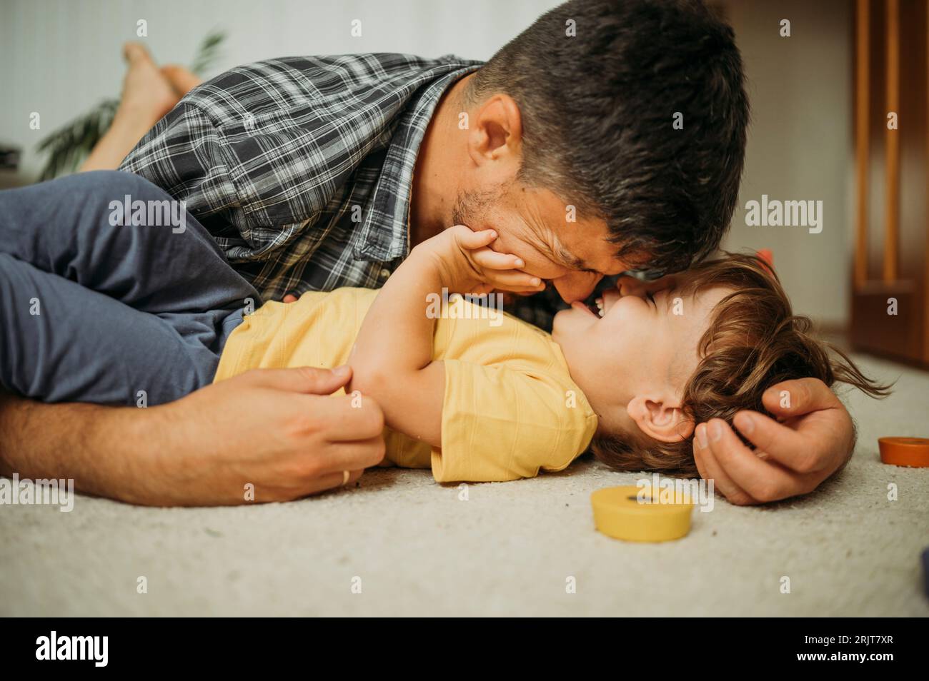 Smiling father spending leisure time playing at home Stock Photo