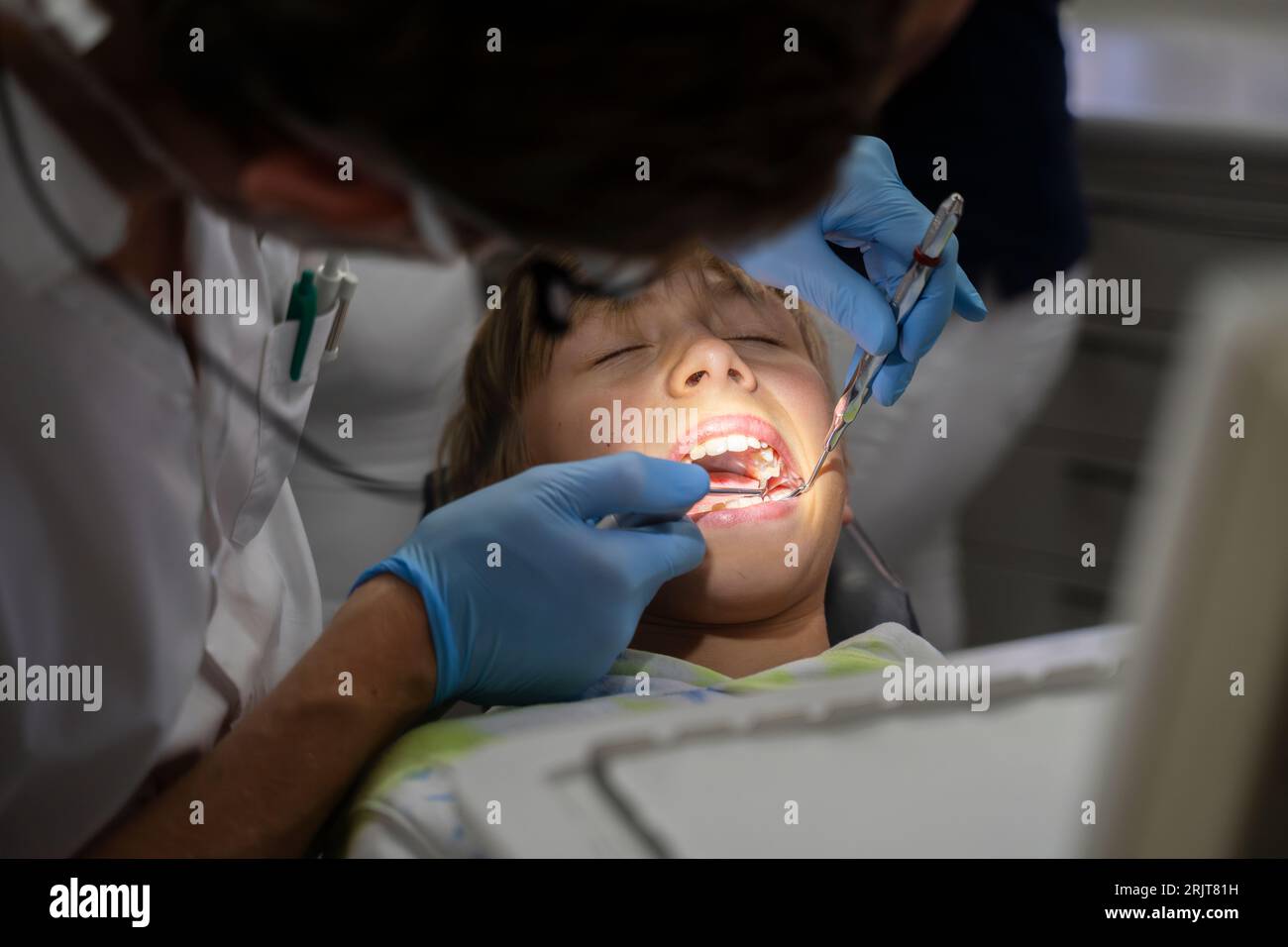 Dentist examining patient's teeth with tools at clinic Stock Photo