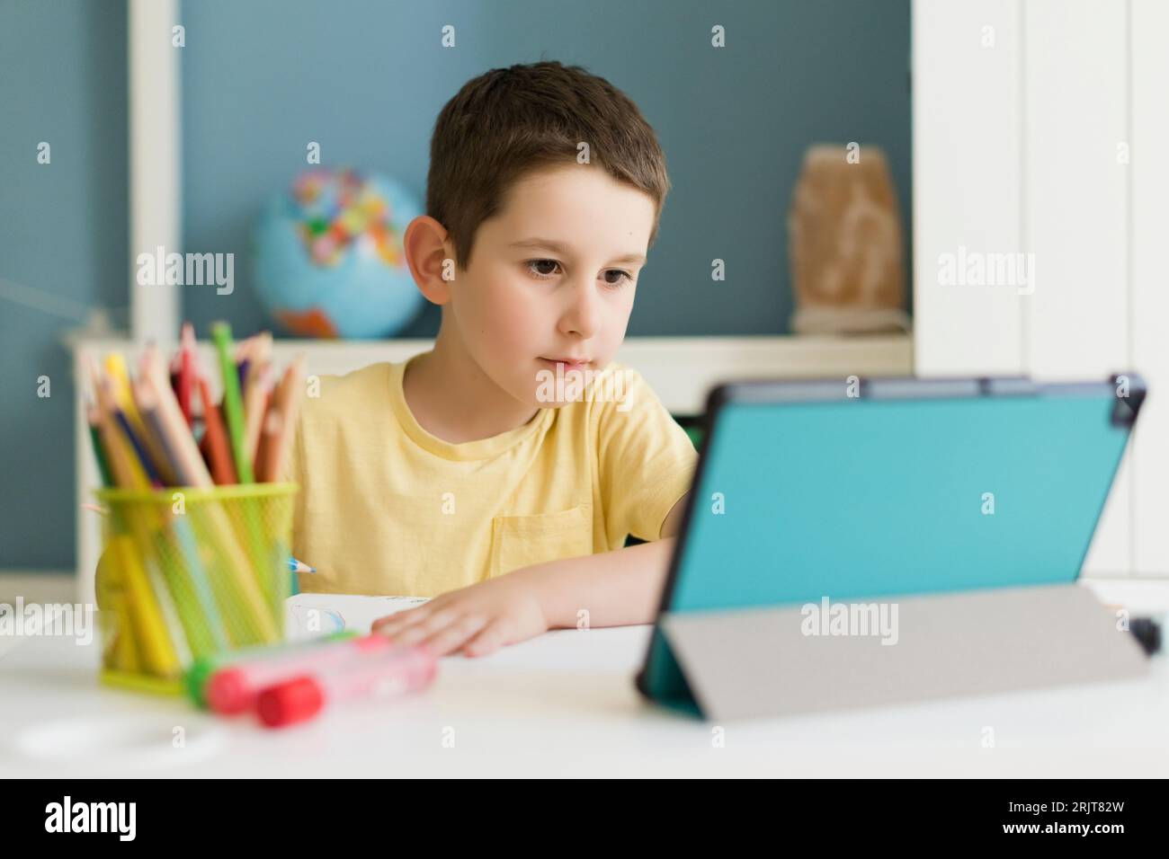 Boy using tablet PC at home Stock Photo