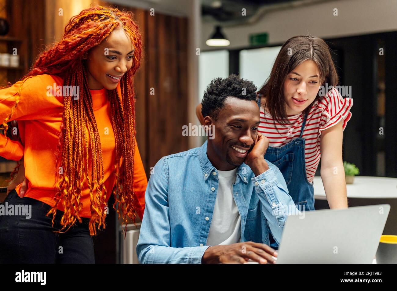 Multi-ethnic business colleagues looking at laptop in office Stock Photo